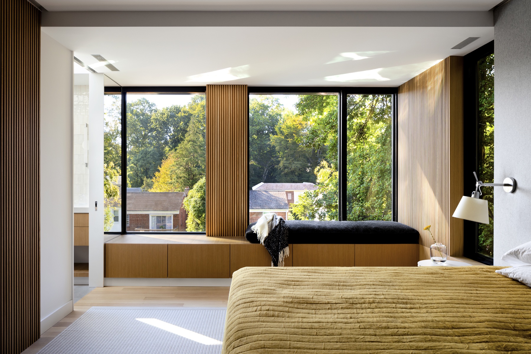 A bedroom with textured wood and views