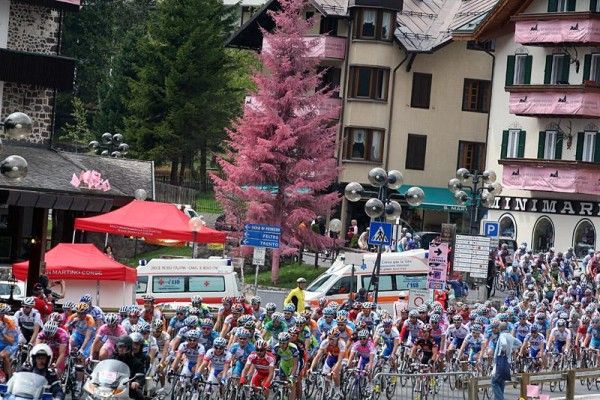 The peloton rolls through the streets of San Martino Di Castrozza at the start of stage five.