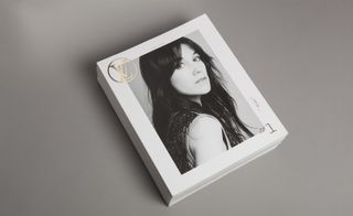 A front cover of a Louis Vuitton magazine with the logo on the top left, a portrait photo of a female with long hair looking over her shoulder in the centre. The number one is written in the bottom right.