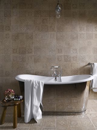 Towel on a Bathtub and wooden side stool in a bathroom.