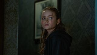Sadie Sink sadly standing in a hall in The Whale,
