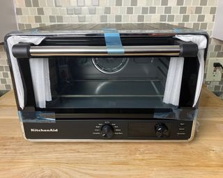 KitchenAid Digital Countertop Oven on wooden countertop with blue adhesive tape