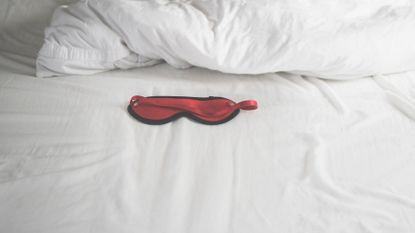 Ann Summers advent calendars 2021 - red satin blindfold on white bed sheets