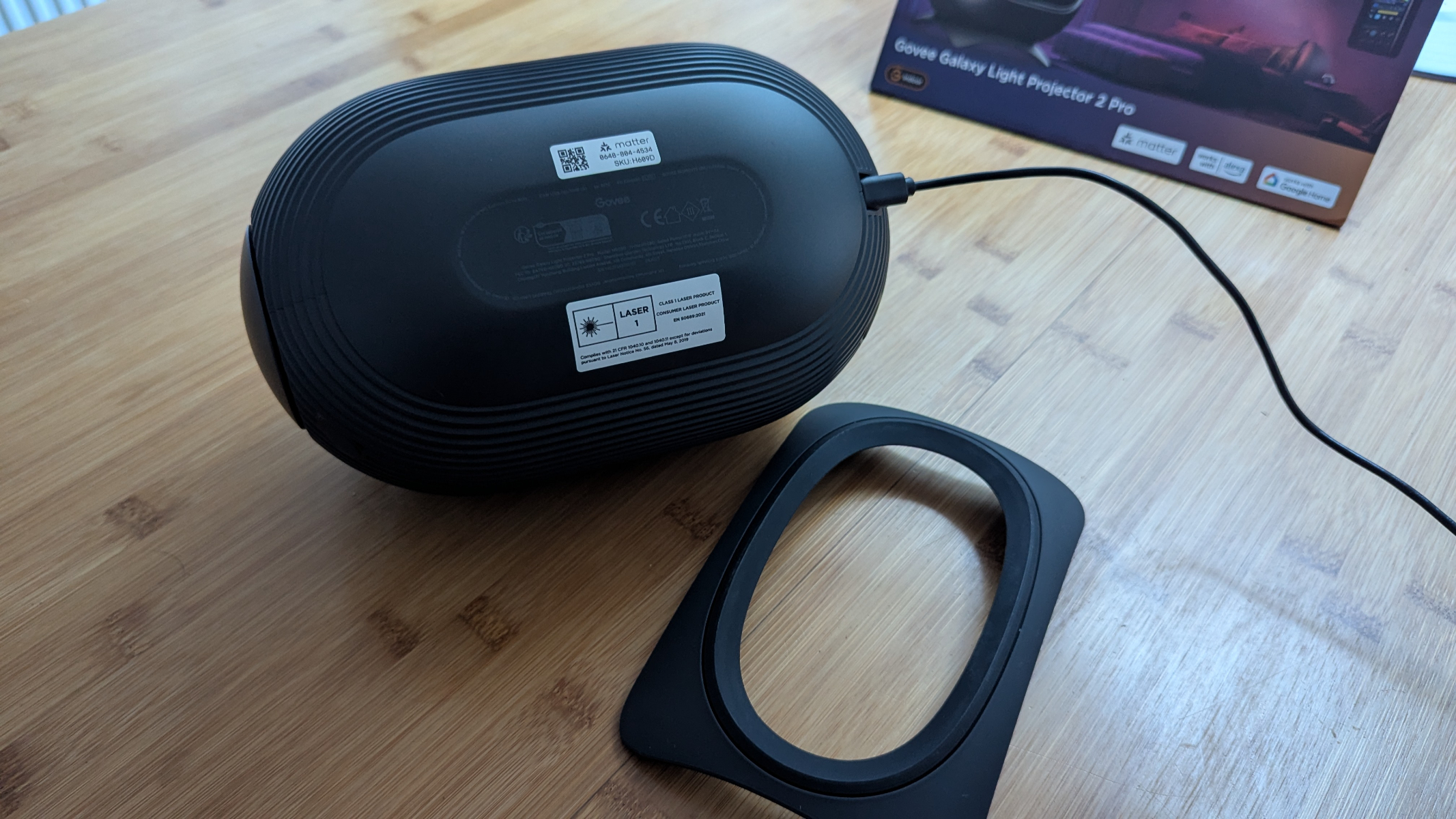 Govee Galaxy Light Projector 2 Pro next to its stand.