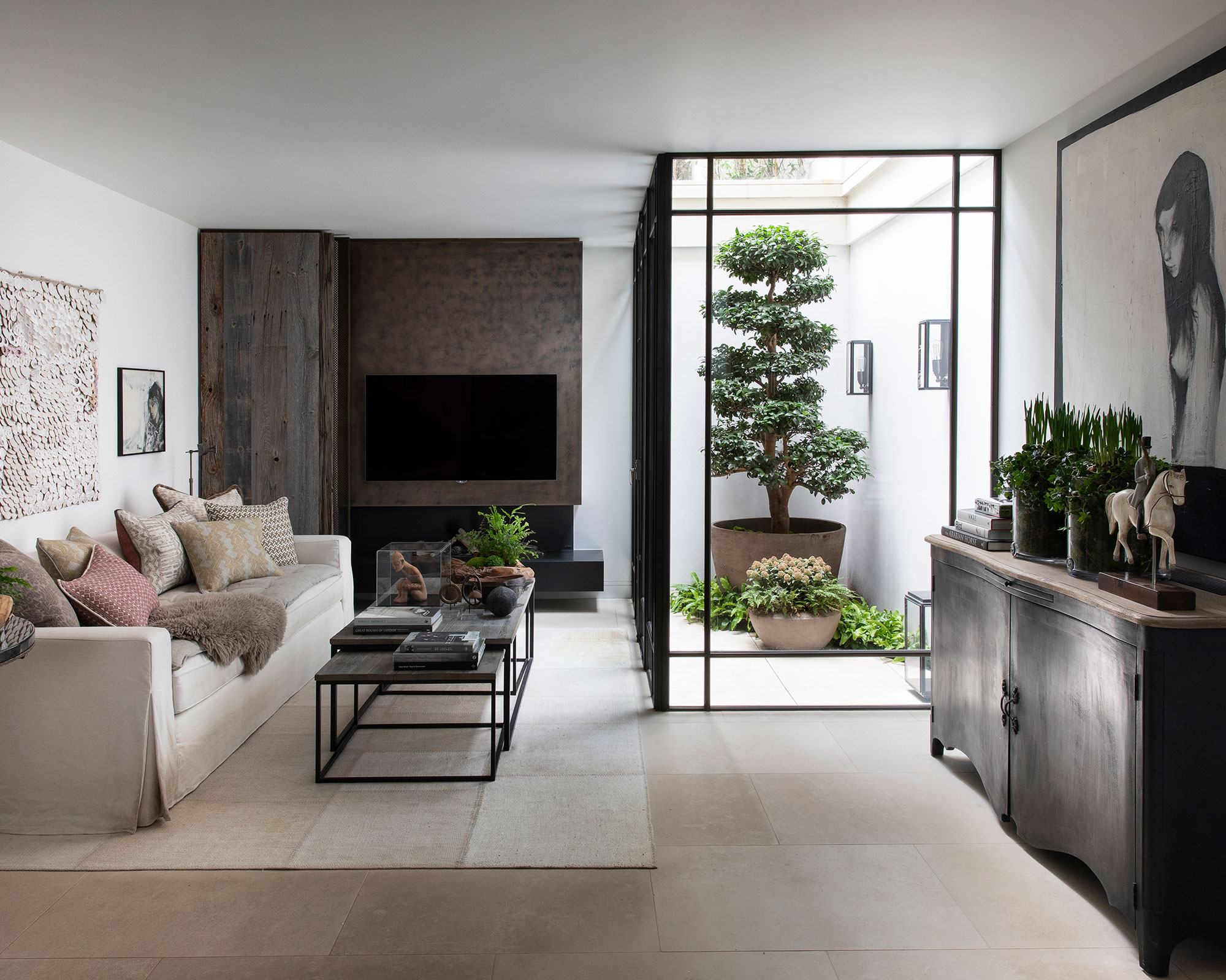 An example of dark living room ideas showing a living room with white painted walls and dark cabinets