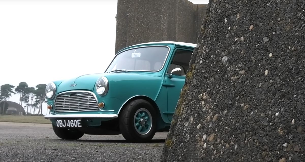 turqoise classic mini behind a concrete bollard