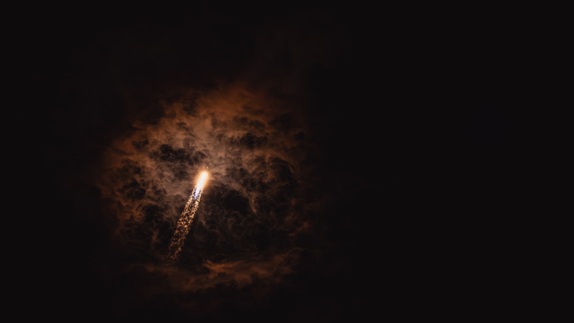 a bright streak of flame visible in an otherwise black night sky