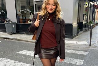 Woman in brown and burgundy outfit.