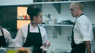 Camille (Izuka Hoyle) and Nick (Steven Ogg) look at one another in the kitchen in Boiling Point episode 3