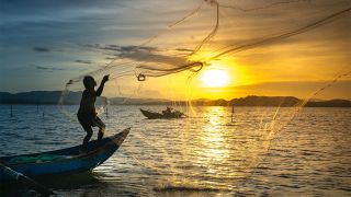 A fisherman casts his net