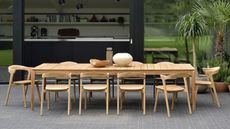 A modern wooden outdoor furniture set featuring a teak patio table and patio chairs