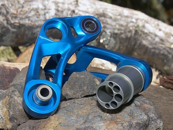 The two sides of the link are rigidly tied together simply by moving the mounting hardware away from the center of rotation.