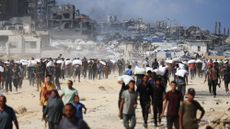 Palestinians carry aid back to their families near Sudaniyyah in Northern Gaza