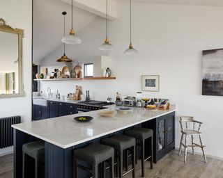 L-shaped kitchen with blue cabinets and marble countertop