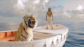 Suraj Sharma as Pi stands on a boat alongside a tiger in Life of Pi