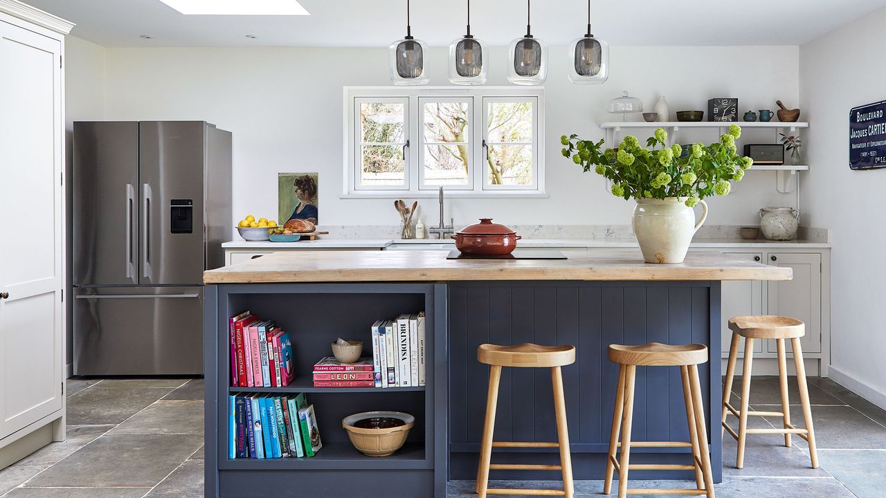 modern kitchen with island, wood bar stools and large stainless steel fridge freezer