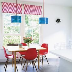 dining area with dining table and red chair and white wall