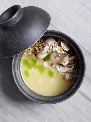 A soup-like dish inside a grey pot.