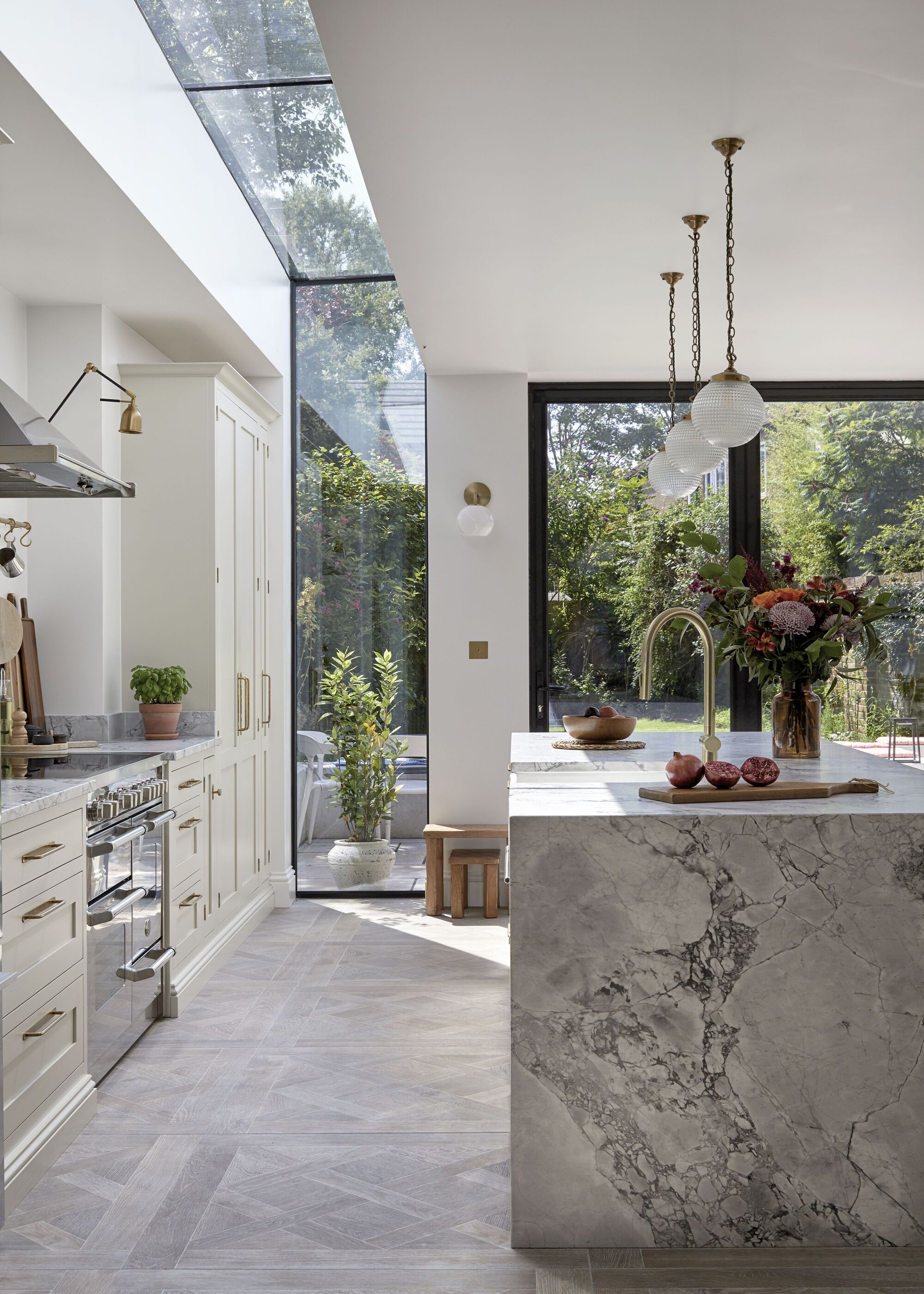 A modern kitchen with cream cabinetry and a stone island with a sink