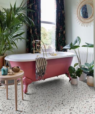 terrazzo flooring in bathroom with red roll top bath