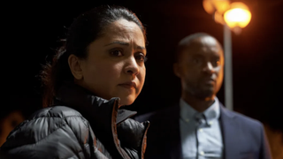 Detective inspector Rachita Ray (Parminder Nagra) looking concerned, with DS Kwesi Edmund (Peter Bankolé) in the background, in DI Ray season 2