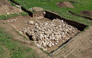 This excavation shows where the hand and the man's grave were unearthed.