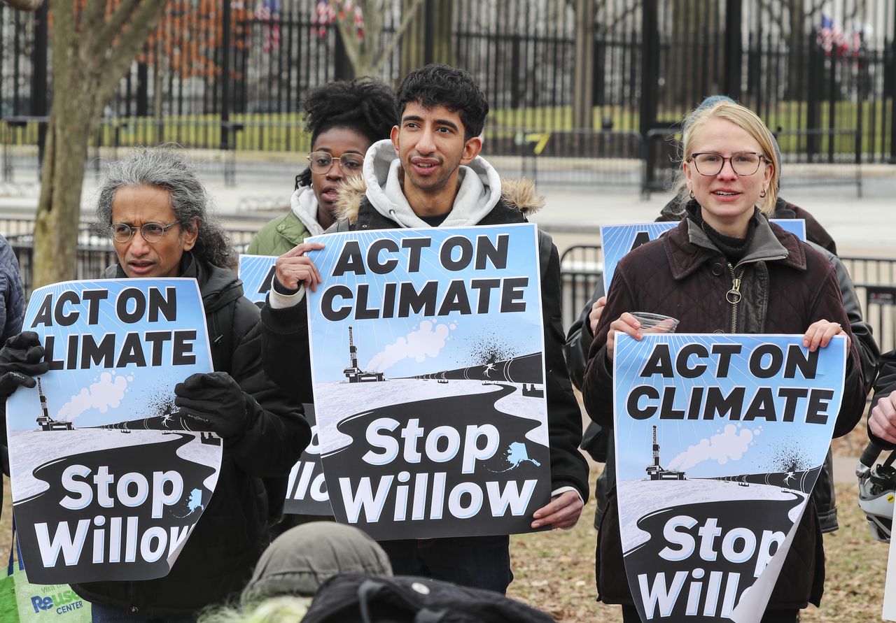 Protesters holding signs calling for blocking the Willow drilling project