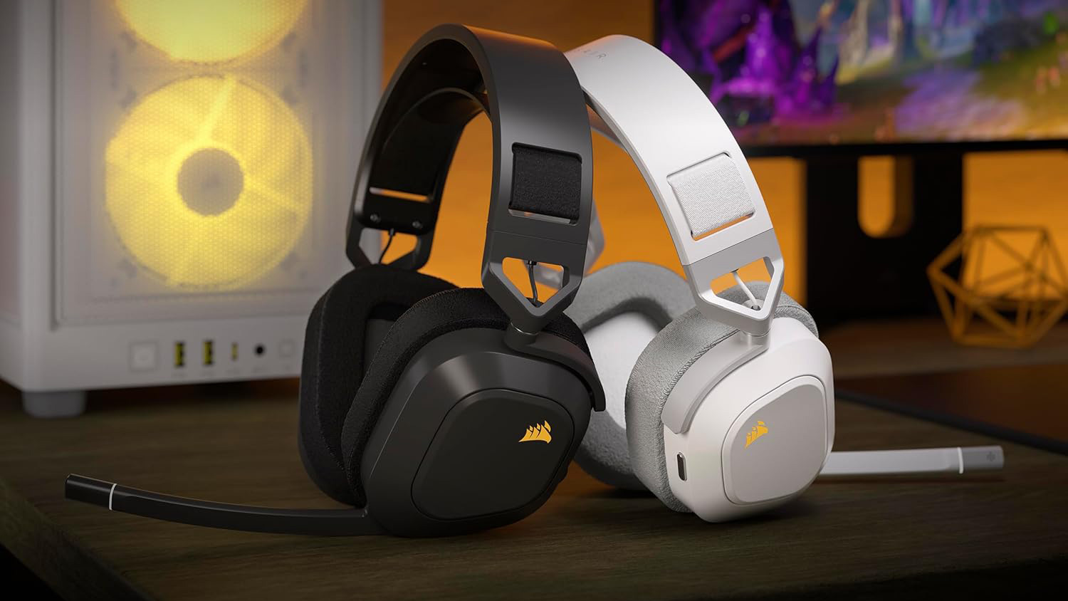 Corsair HS80 Max Wireless headsets in black and white on top of desk in front of gaming tower