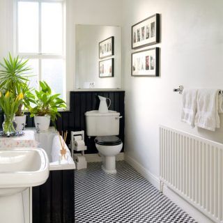 black and white bathroom with checked floor and plain walls
