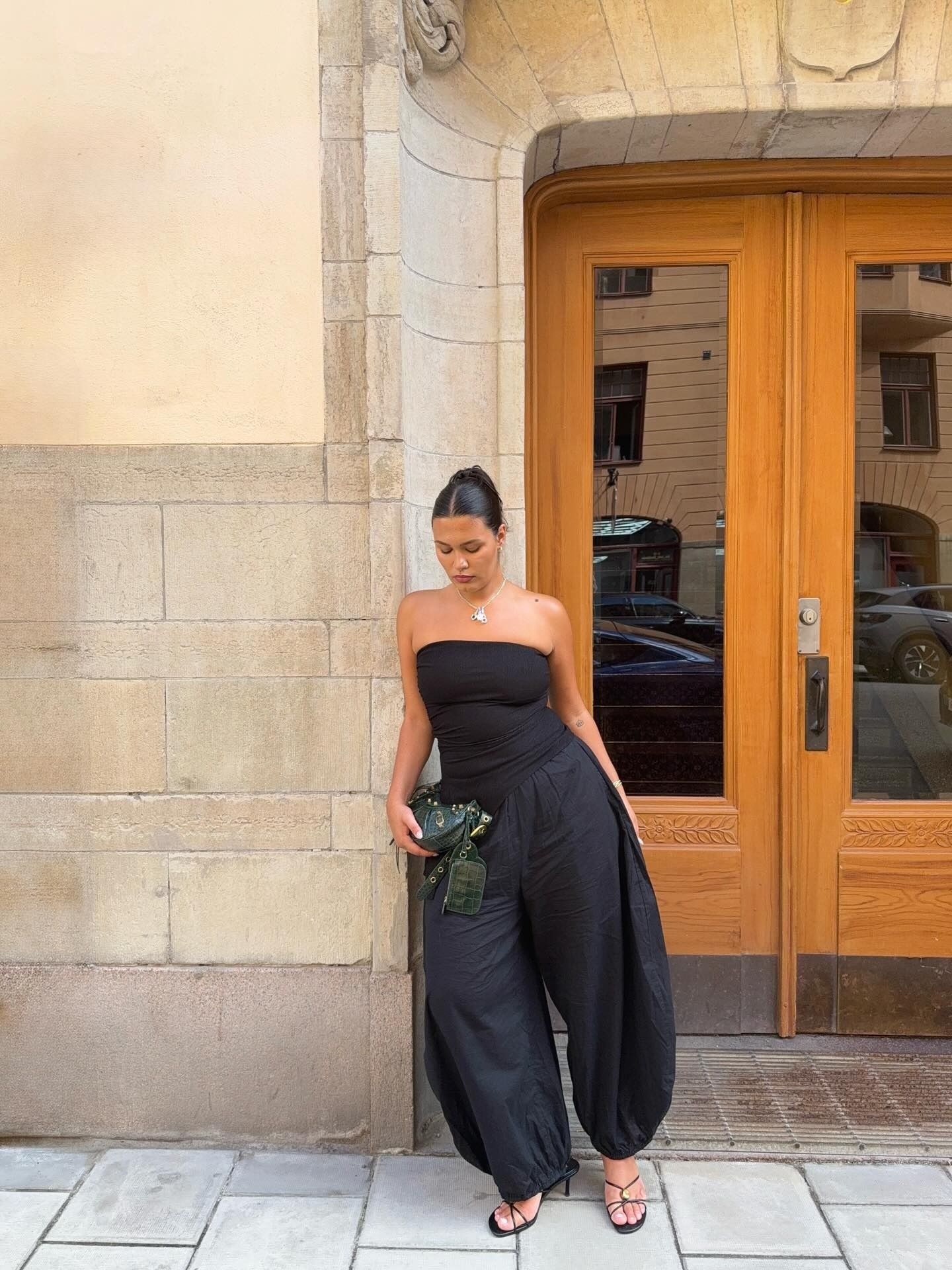 Influencer @isabellecoheen wears balloon trousers with strappy heels and a strapless top.