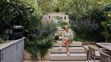a woman and a dachshund in a modern garden surrounded by purple planting 