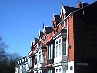 Low-res photo of a row of houses under a blue sky