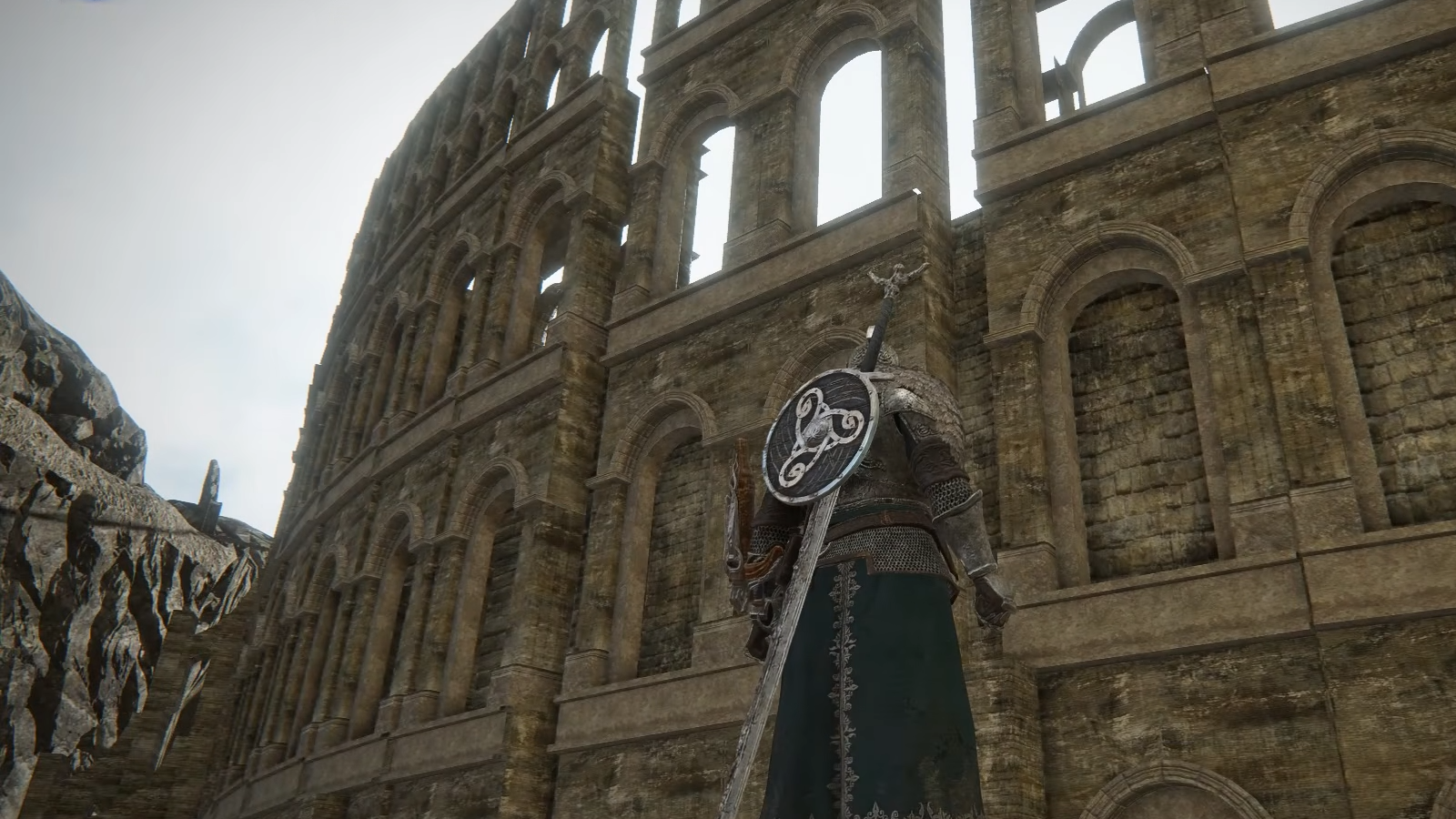 Nightreign gameplay view of cut map from Dark Souls 2, showing Faraam Wylder looking up at the side of a massive coliseum wall.