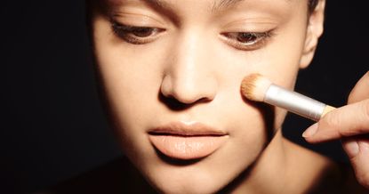 woman applying foundation