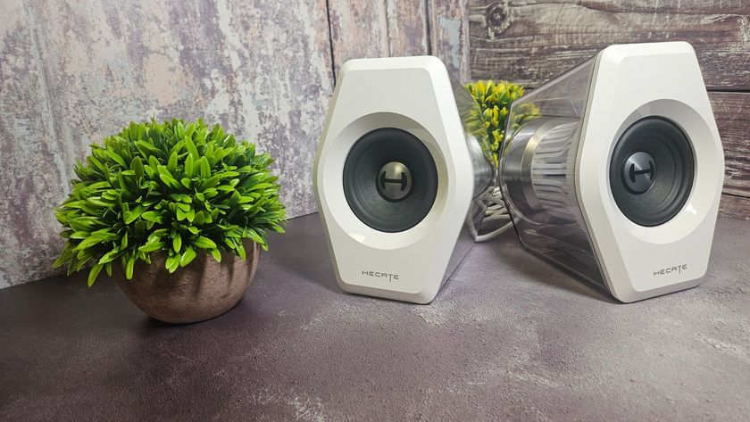 The Edifier G2000 Pro speakers on a desk next to a small house plant