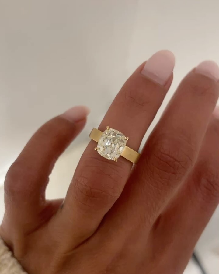 Woman wearing radiant cut diamond engagement ring.