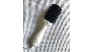 Image showing the BondiBoost Blow Dryer Brush against a textured white fabric background