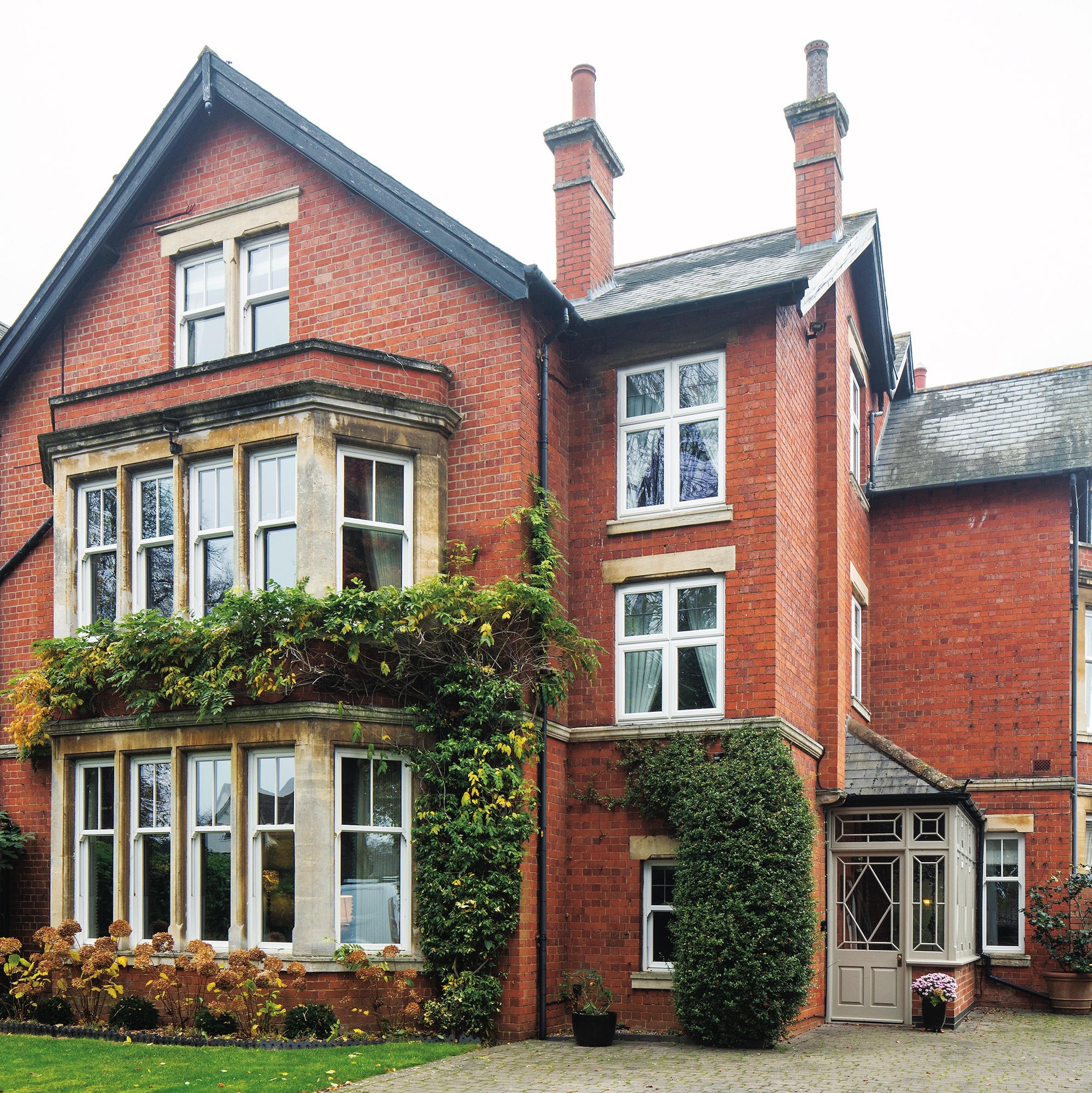 exterior of red brick Edwardian house with pitched roof and large bay windows on ground and first floor