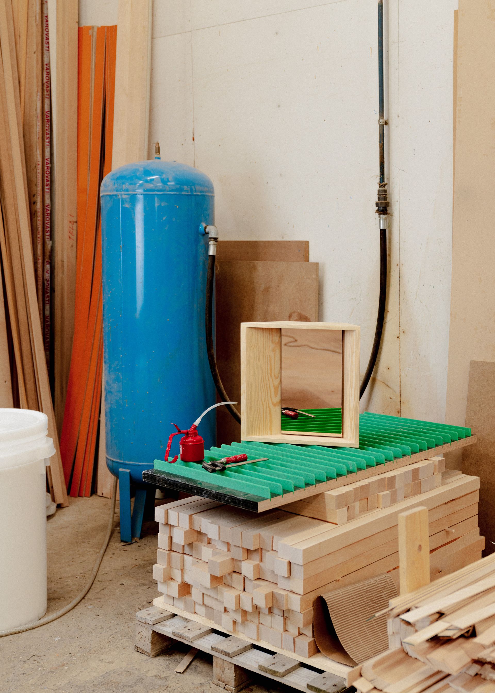 Wood framed mirror on green surface in factory