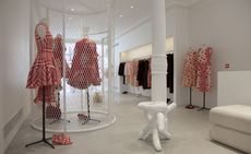 A selection of red and white outfits in a white shop interior