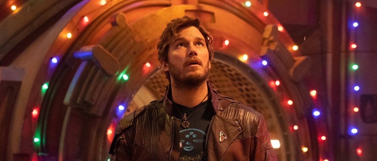 Chris Pratt as Peter Quill/Star-Lord in front of holiday lights adorning a metal entrance in The Guardians of the Galaxy Holiday Special