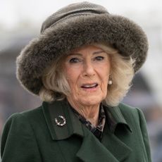 Queen Camilla wearing a green coat and fur hat