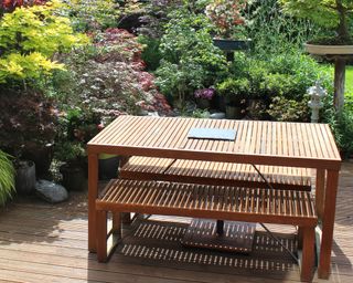 Wooden slat garden dining table and benches in zen garden