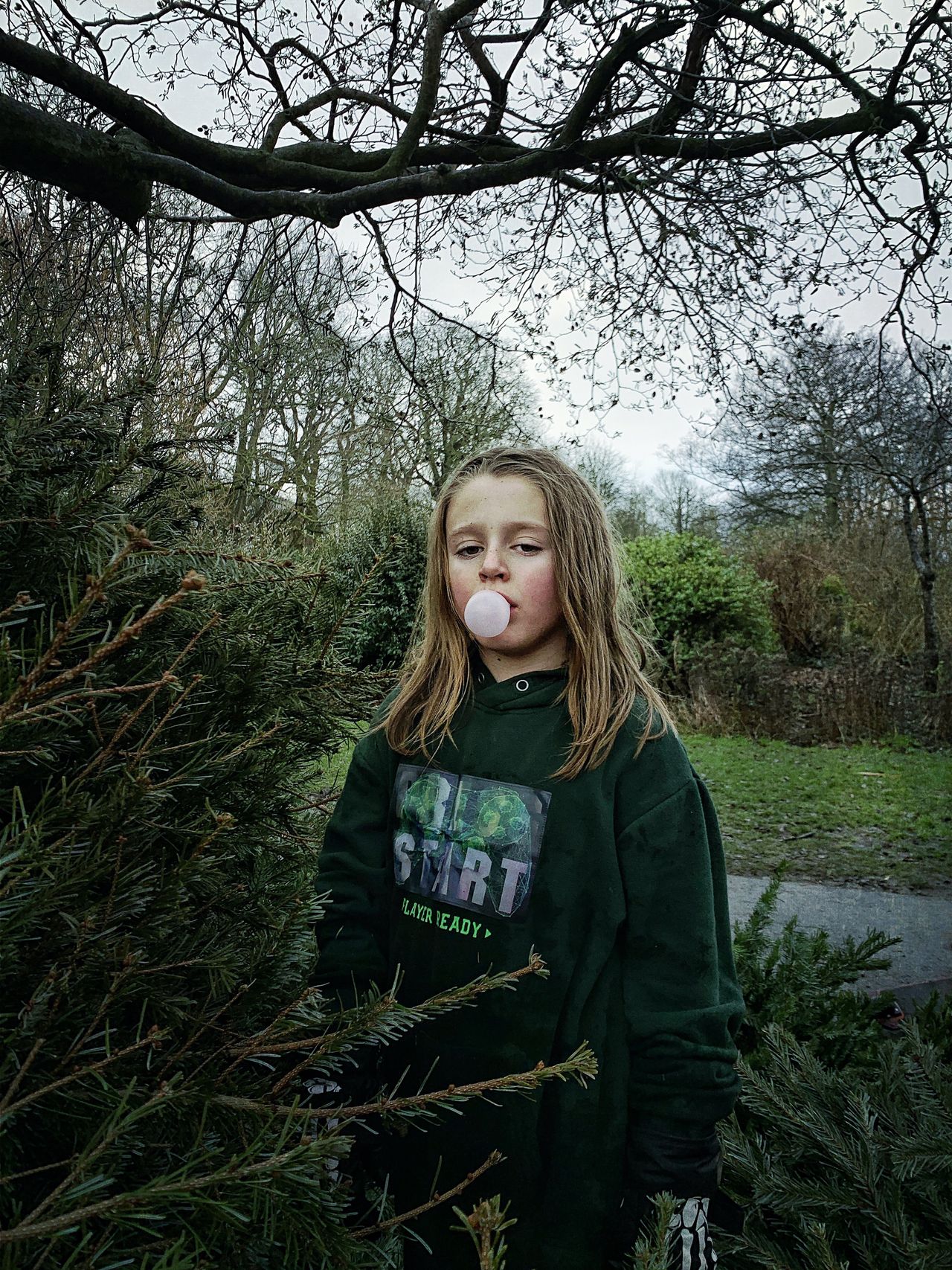 The Christmas Trees photo showing girl blowing bubble gum for the iPhone Photography Awards 2021