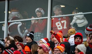 Taylor Swift wearing a Santa hat adorned with Travis Kelce's number, 87, at a Kansas City Chiefs game in December 2023.