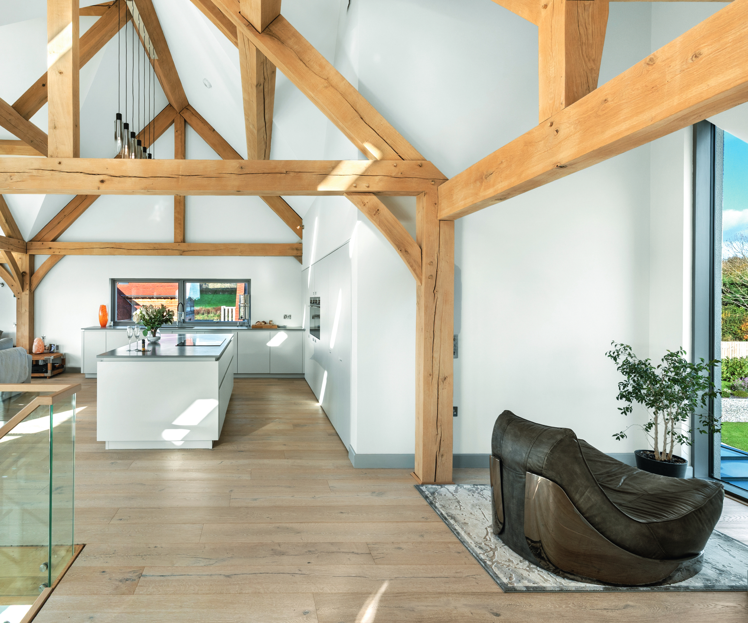 inside living and kitchen space of oak frame home with exposed structural beams