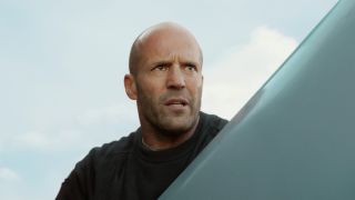 Jason Statham holds a huge object, looking prepared for battle in Meg 2: The Trench.