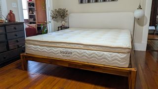 Saatva Latex Hybrid Mattress feature review, with a queen-size undressed Saatva Latex Hybrid Mattress in tester Alex's bedroom