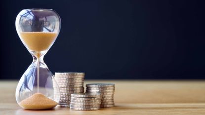 Hourglass timer and stacks of coins