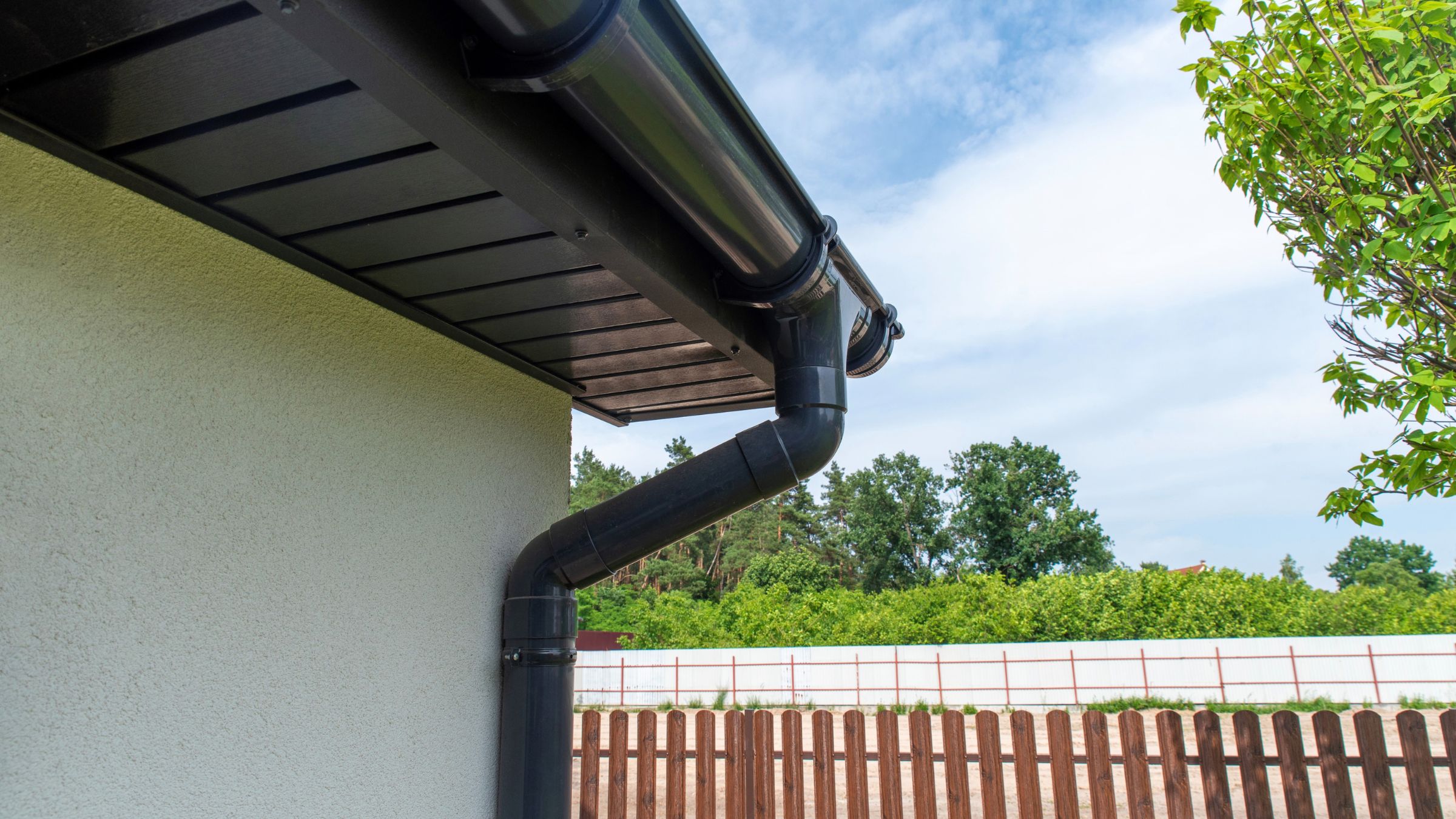 Plastic gutter on eaves of house